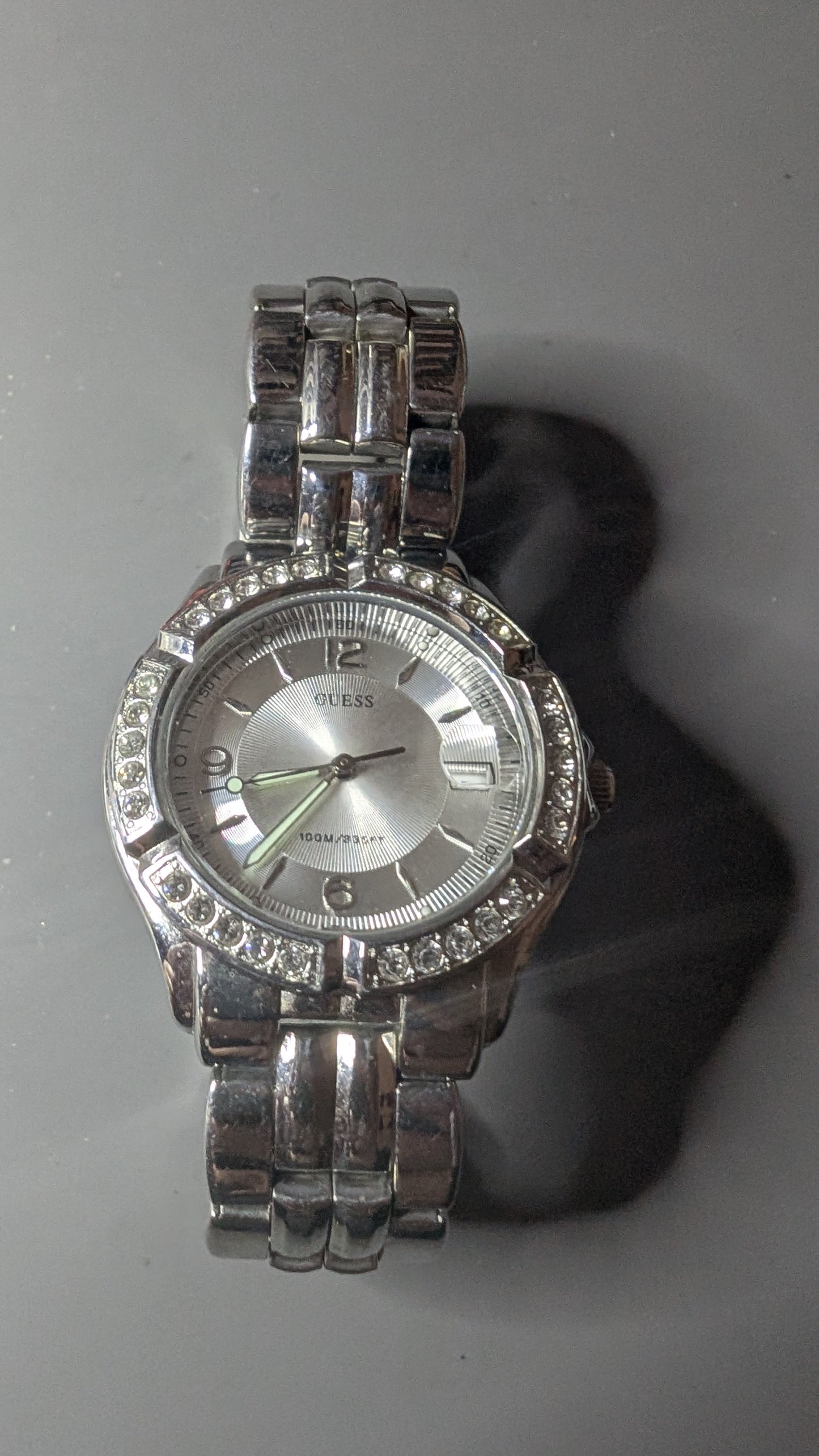 Guess men's sports watch with crystals on the bezel. This is a nice clean watch that keeps good time and has a new battery.