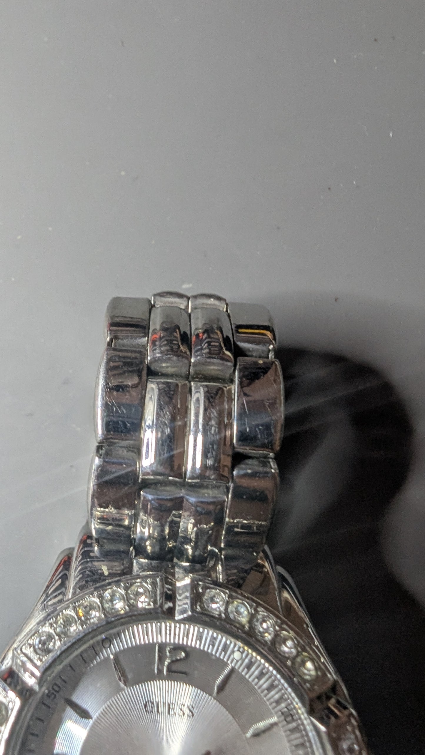 Guess men's sports watch with crystals on the bezel. This is a nice clean watch that keeps good time and has a new battery.